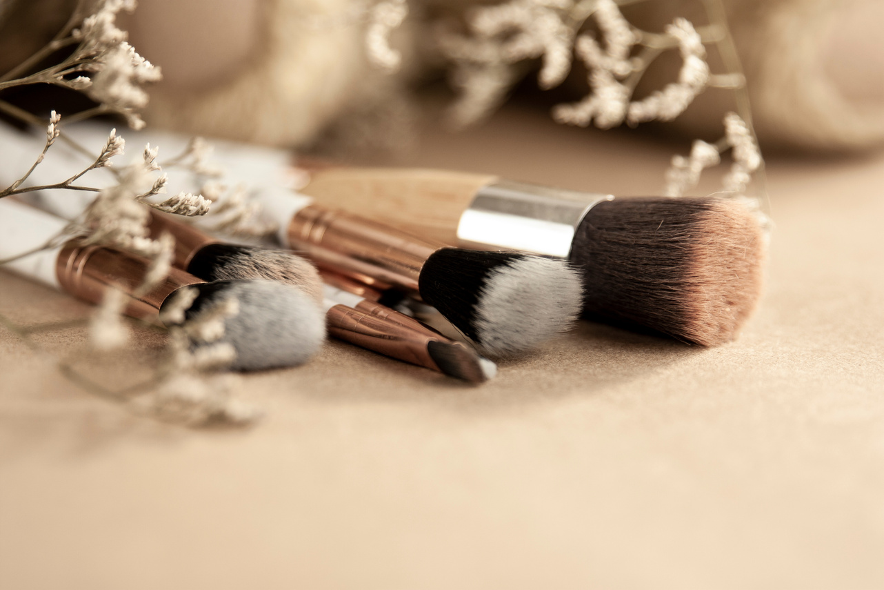 Different makeup brushes and dried flowers